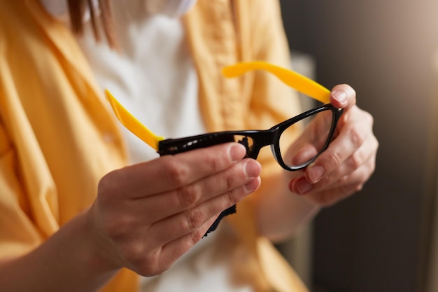 Closeup shot of faceless woman holding in hands optical glasses wipes spectacles Healthcare and vision