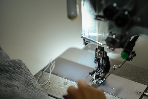 Closeup shot of female hands using a sewing machine