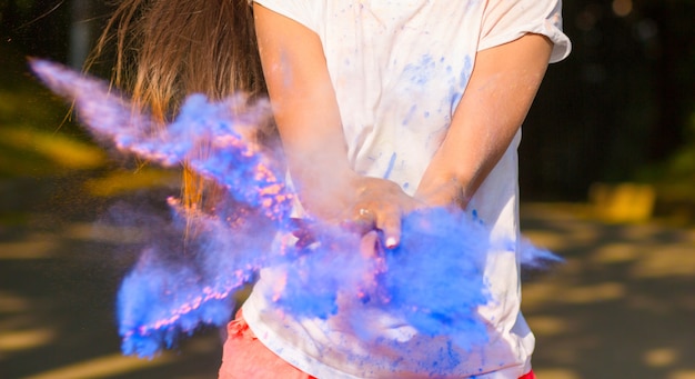 Closeup shot of female hands with exploding Holi powder