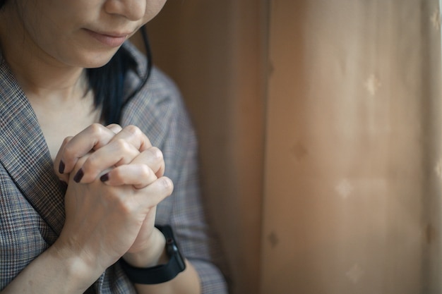 Closeup shot of a female praying at home. christian concept.