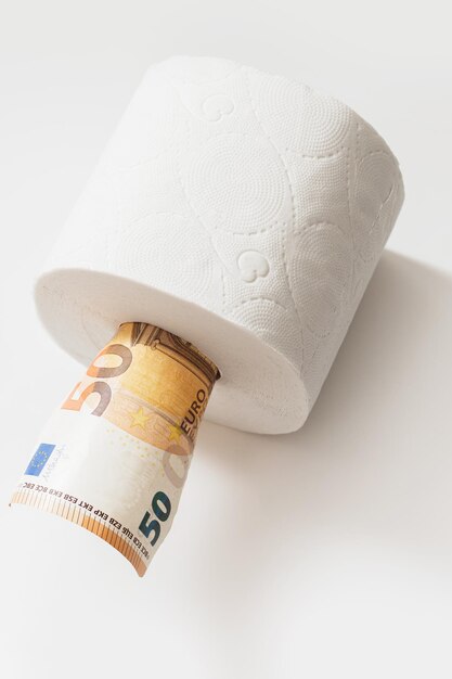 Closeup shot of fifty euro banknote put inside a toilet paper roll Concept of essentials shortage during covid19 pandemic