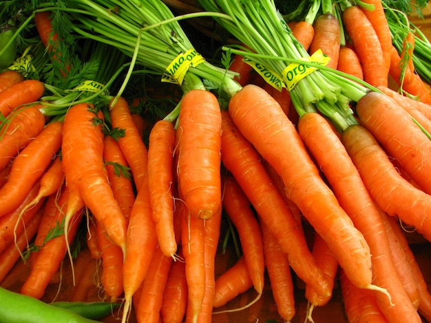 Closeup shot of fresh bundles of carrots with yellow tape displayed in a grocery