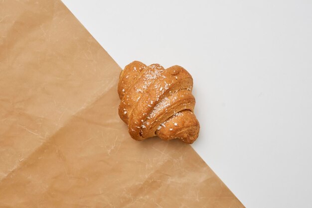 Closeup shot of a fresh croissant on the tracing paper