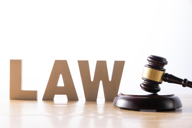 Closeup shot of a gavel and the word Law on a wooden surface