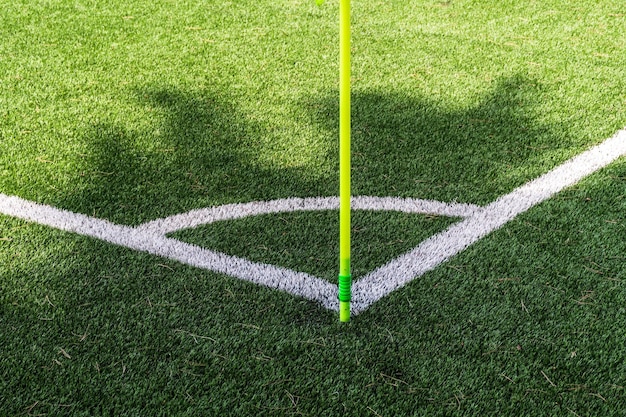 Крупный план зеленого углового флага на углу футбольного поля