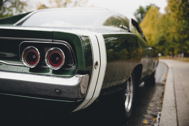 Photo a closeup shot of a green muscle car on a blurred background