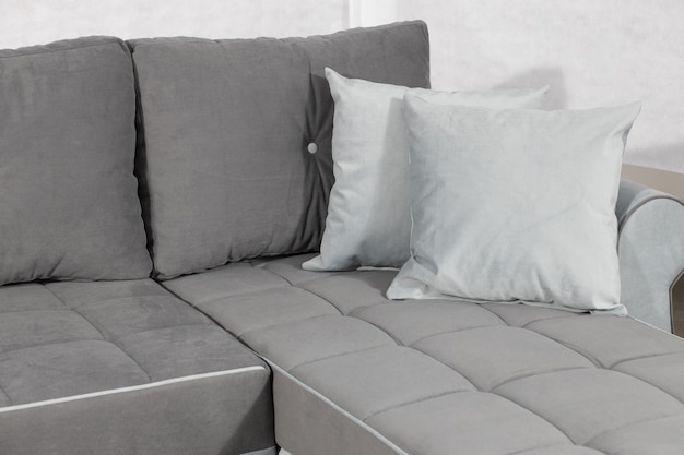 Closeup shot of a grey modern couch with pillows in a room