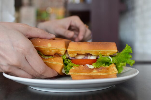 クローズアップショット食べ物とコーヒードリンクを持っている手