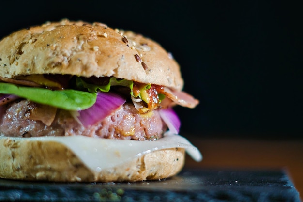 Photo closeup shot of a handmade hamburger on a slate board