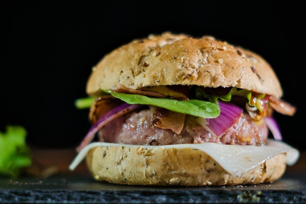 Photo closeup shot of a handmade hamburger on a slate board