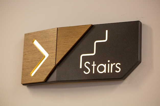 Closeup shot of a horizontal wooden guiding sign leading to the stair