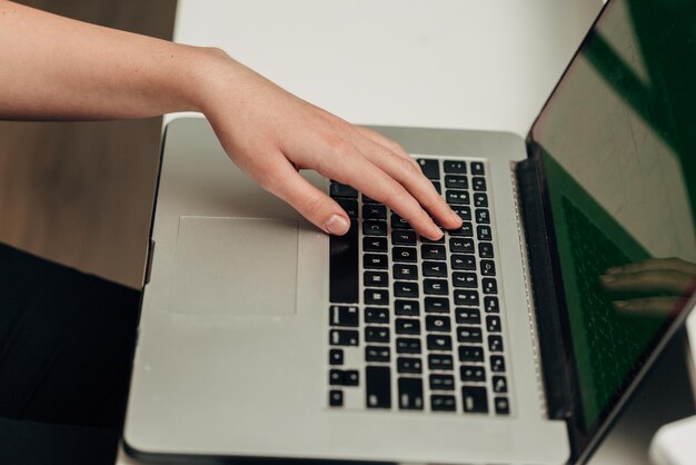 Photo closeup shot of human hands placed over laptop