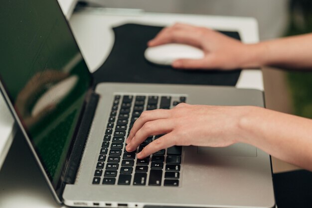 Photo closeup shot of human hands placed over laptop