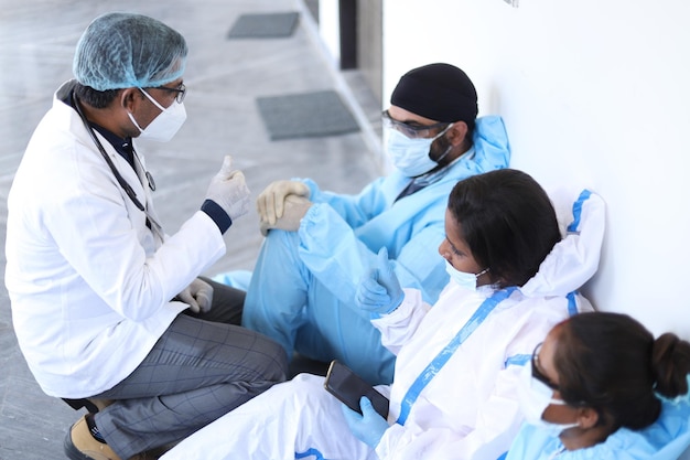 Closeup shot of Indian doctors with medical uniform and mask discussing COVID-19