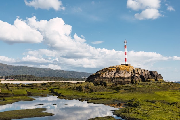 Primo piano di un faro su una spiaggia rocciosa