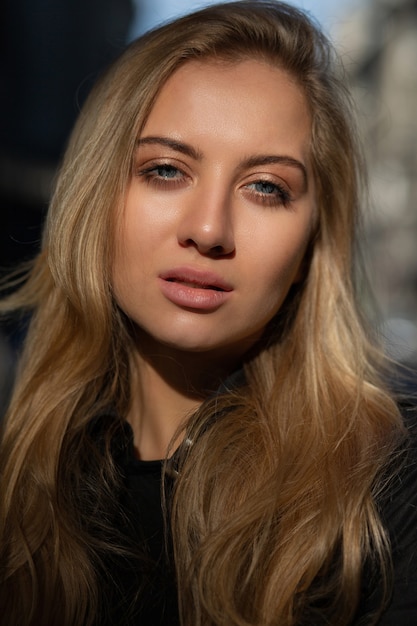 Closeup shot of luxury woman with natural makeup posing with soft sun light