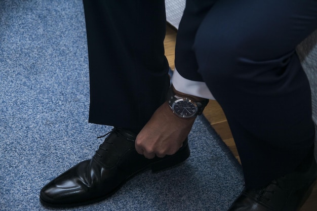 Photo closeup shot of a male in a formal suit wearing elegant black shoes