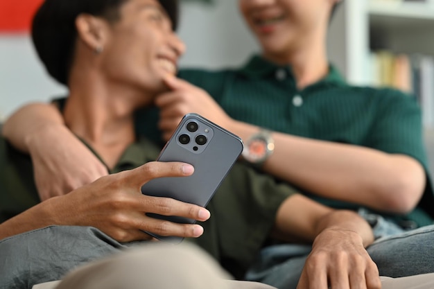 Closeup shot of man holding smartphone and talking with his boyfriend LGBT love and lifestyle relationship concept