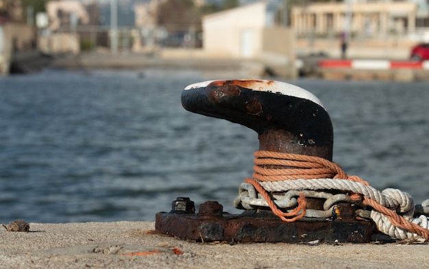 Closeup shot of marine rope on mooring bollard in port