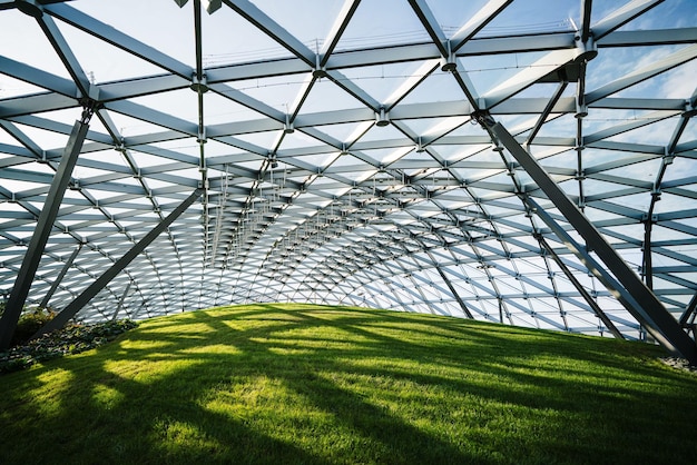 Closeup shot of a modern metal structure over green field under sunlight