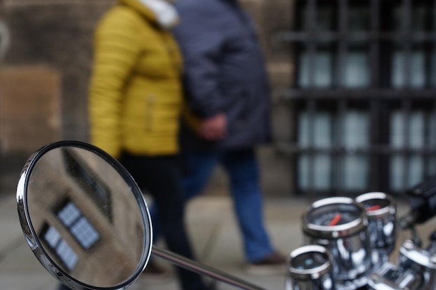 Closeup shot of motorcycle against people walking