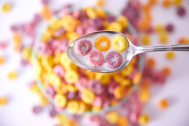 Closeup shot of multicolored fruity cereals in a blue bowl isolated on white background