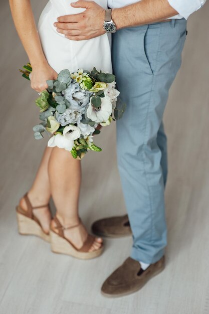 Closeup shot of newlyweds hands with wedding bouquet