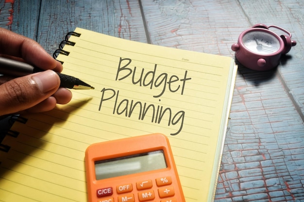 写真 書き込み予算計画の黄色いノートブックのページのクローズアップショット