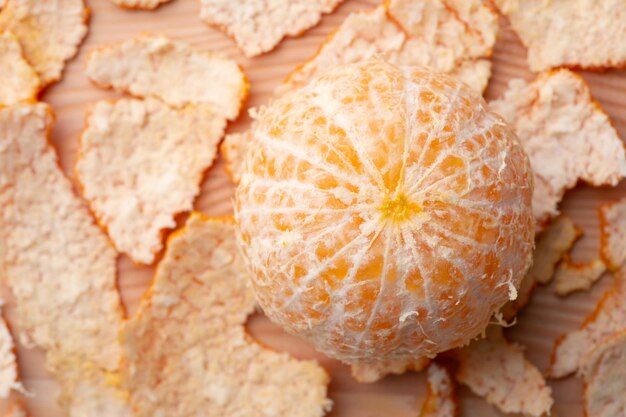 Closeup shot of peeled out tangerine with many peels around Tasty juicy tangerine on a table