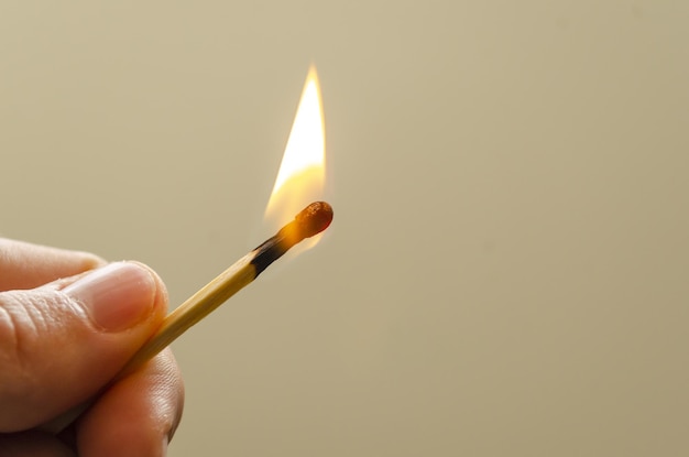 Closeup shot of a person holding a burning matchstick