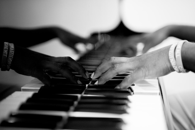 Closeup shot of a person playing the piano in black and white with a blurred background