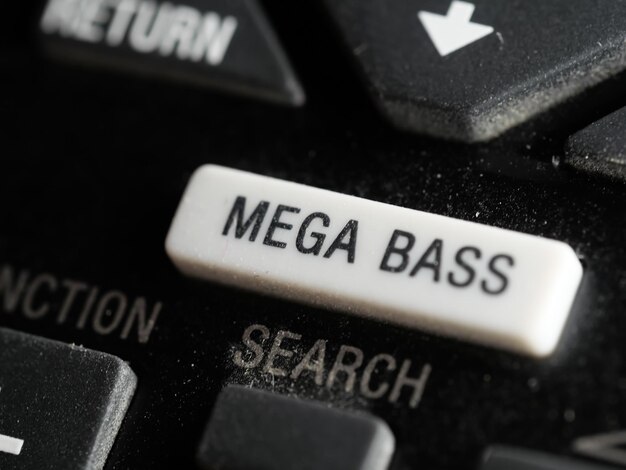 黒の背景にMEGA BASSの白いボタンが付いたリモコンのクローズアップショット