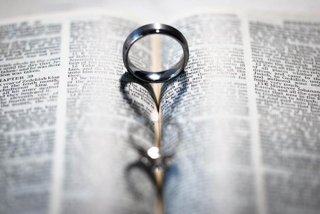 Foto una ripresa ravvicinata di un anello che fa un'ombra a forma di cuore su un libro