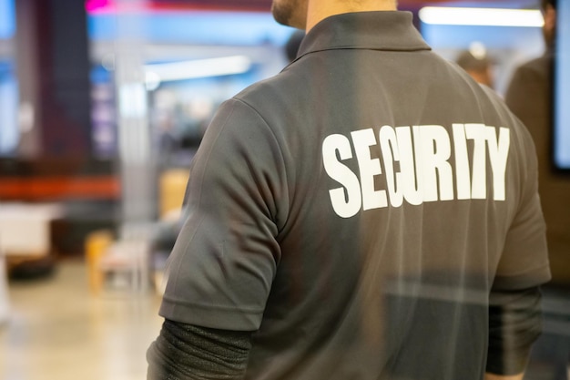 Photo closeup shot of a security guard inside a commercial building with reflection light in window