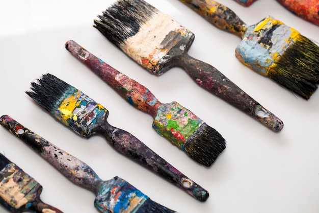 Photo closeup shot of a set of dirty paintbrushes on a white background