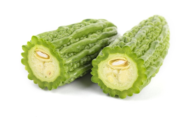 Closeup shot of sliced green bitter gourds on a white