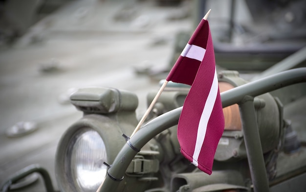 Closeup shot of the a small Latvian flag on a metal railing