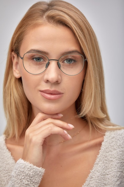 Closeup shot of smiling attractive happy and successful european blond female in sweater watch and glasses grinning expressing confidence looking accomlished and daring at camera with sassy smile