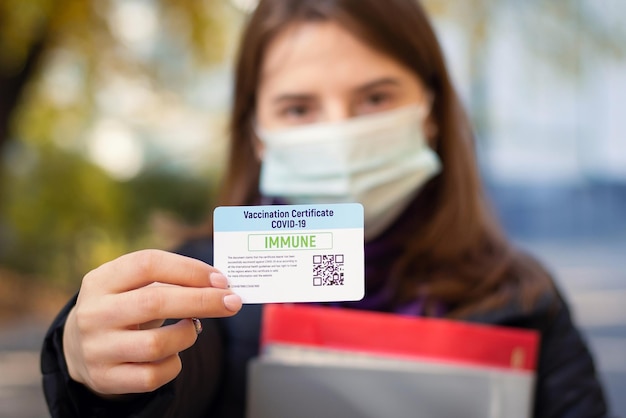 Foto primo piano di uno studente che mostra il certificato di vaccinazione alla telecamera