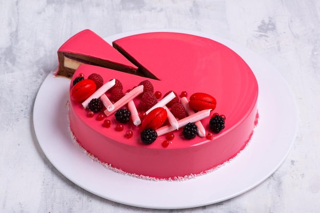 Closeup shot of a tasty cake topped with candies and fresh fruits