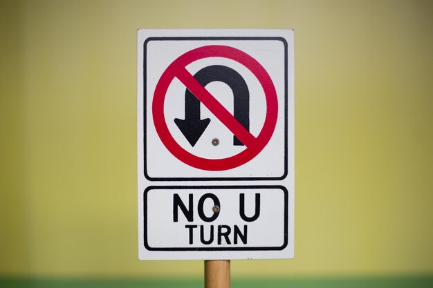 Photo closeup shot of a white no uturn sign on a blurred background