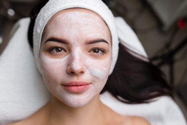 Closeup shot of a woman getting facial treatment with clay mask Cosmetology and spa