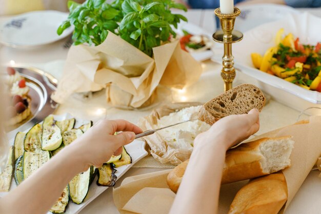 Closeup shot of a woman making a cream cheese sandwich at the festive table