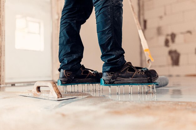 A closeup shot of a worker applying grey epoxy resin on the floor