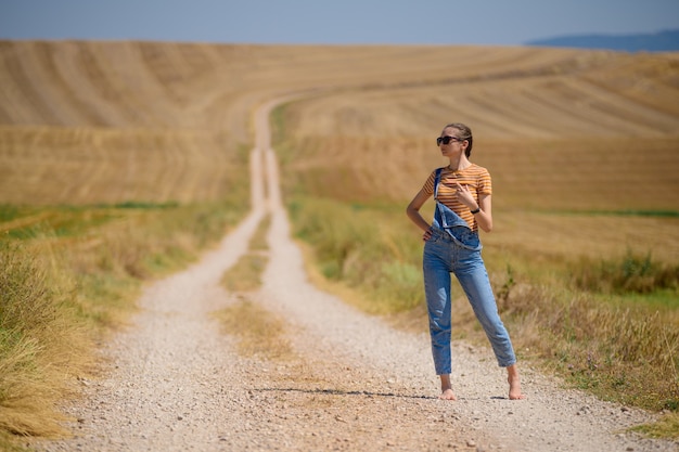 フィールドの小道に立っている若い女性のクローズアップショット