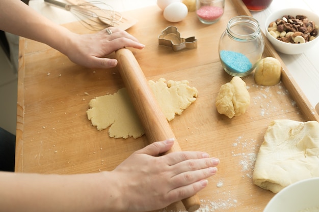 Colpo del primo piano della giovane donna che produce pasta dolce per i biscotti