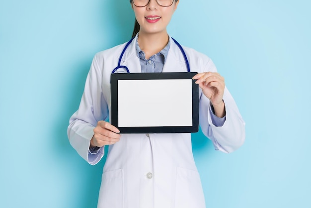 closeup of showing a tablet holding in hands by a female doctor who has a pretty smiley.