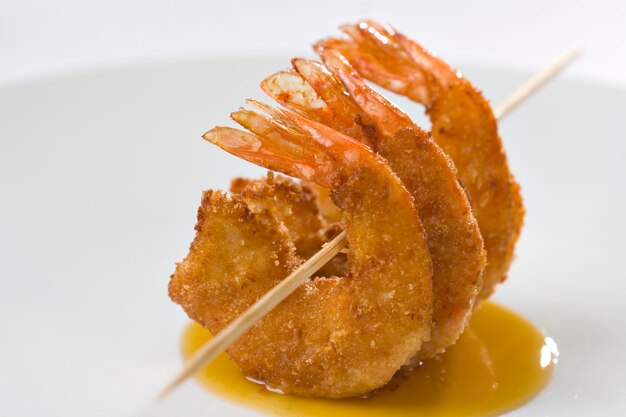 Closeup of shrimp over sauce, served on a white plate