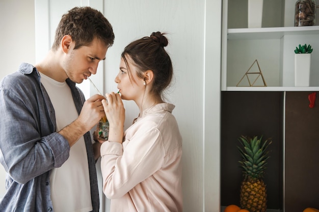 Closeup side view of a couple sharing a drink in the kitchen spending the morning together