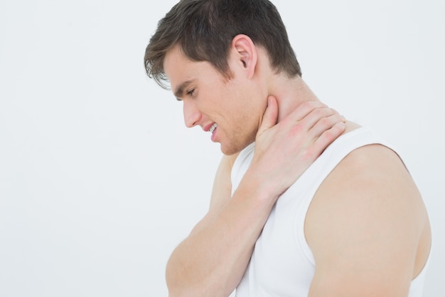 Closeup side view of a man suffering from neck pain